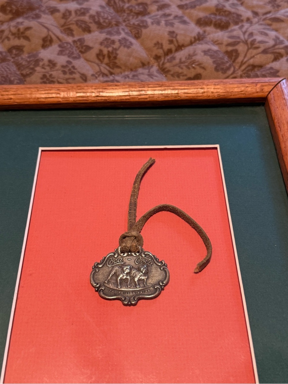 Coca-Cola Brown Leather Cord with Silver Metal Pendant on Red Mat